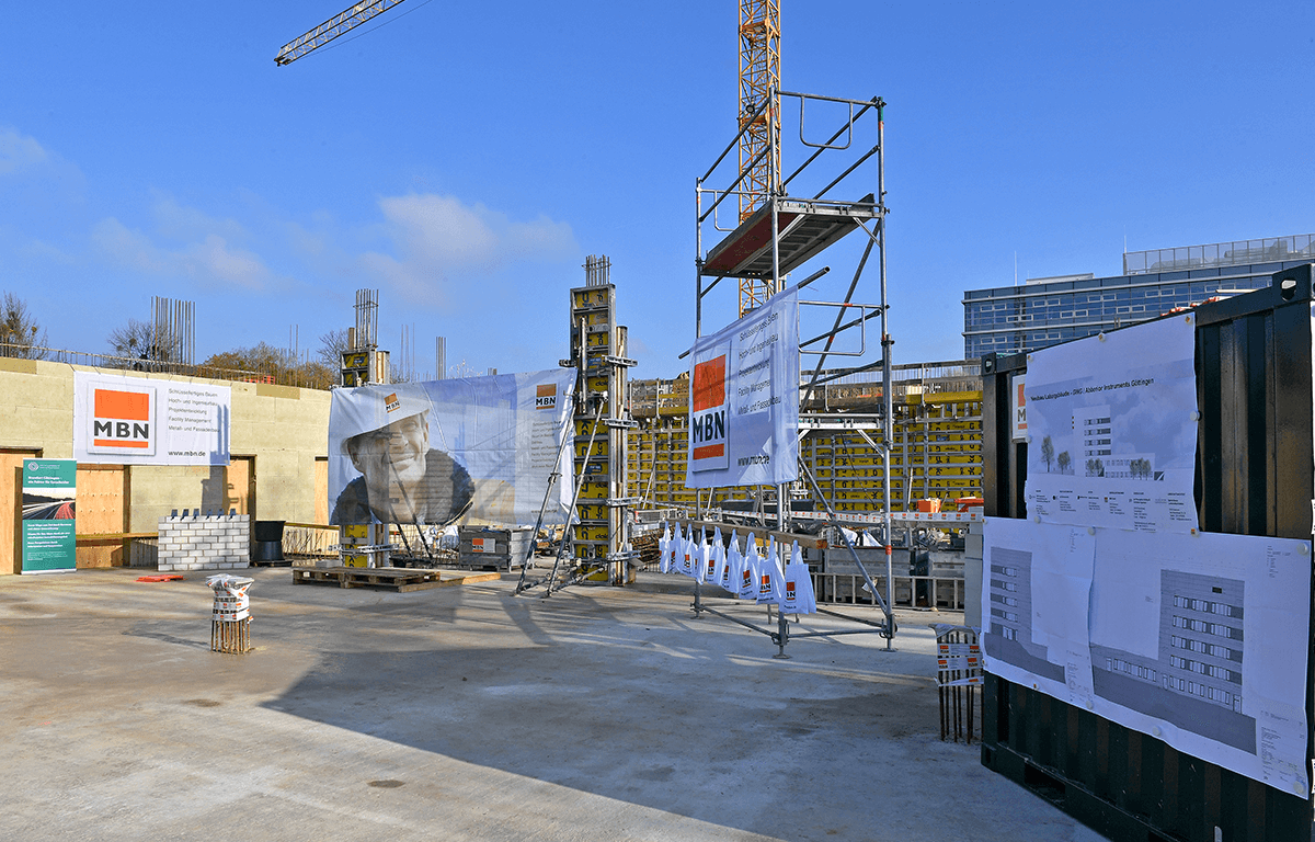 An overview of the building site with banners and scaffolding